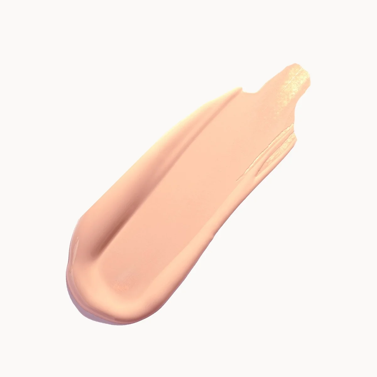 A smooth, creamy swatch of light peach-beige cosmetic cream, likely foundation or concealer, shown on a clean white background.