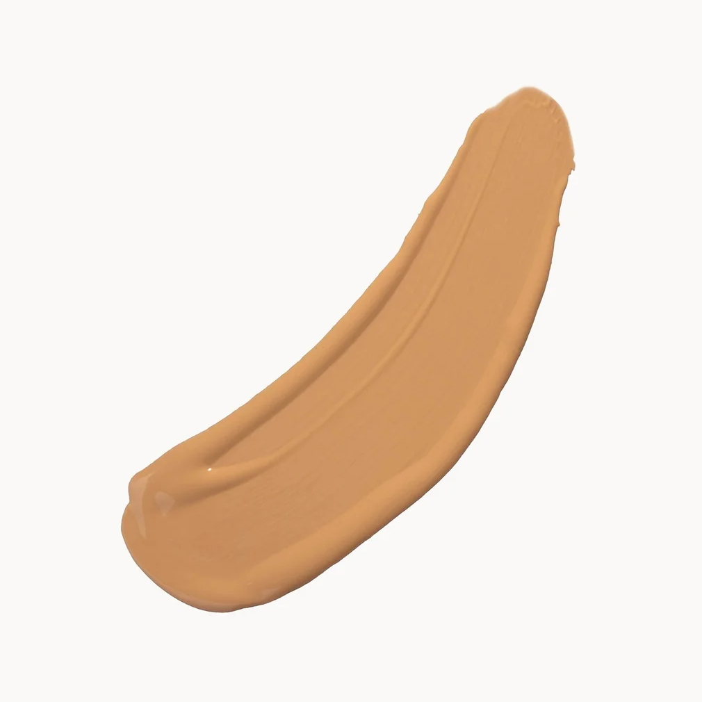 A thick, smooth swatch of warm tan liquid foundation or cream makeup on a plain off-white background.