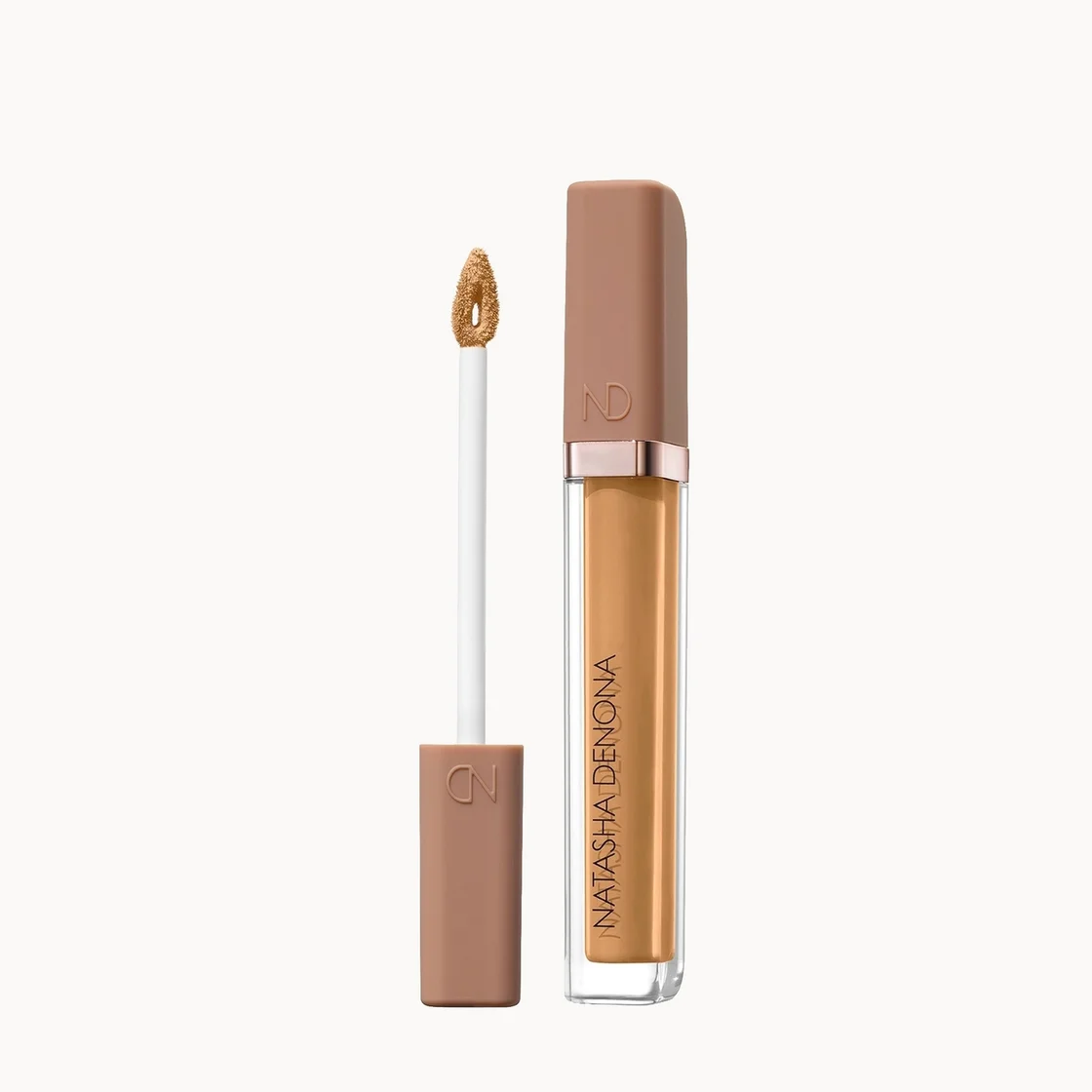 Natasha Denona liquid concealer shown with the applicator wand and cap beside the open tube, on a clean white background.