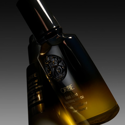 Oribe Gold Lust hair oil bottle on a dark background