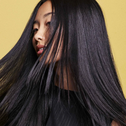Woman with long black hair against a yellow background