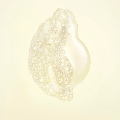 A single translucent, pearlescent droplet or blob with dense bubble texture on a soft cream background.