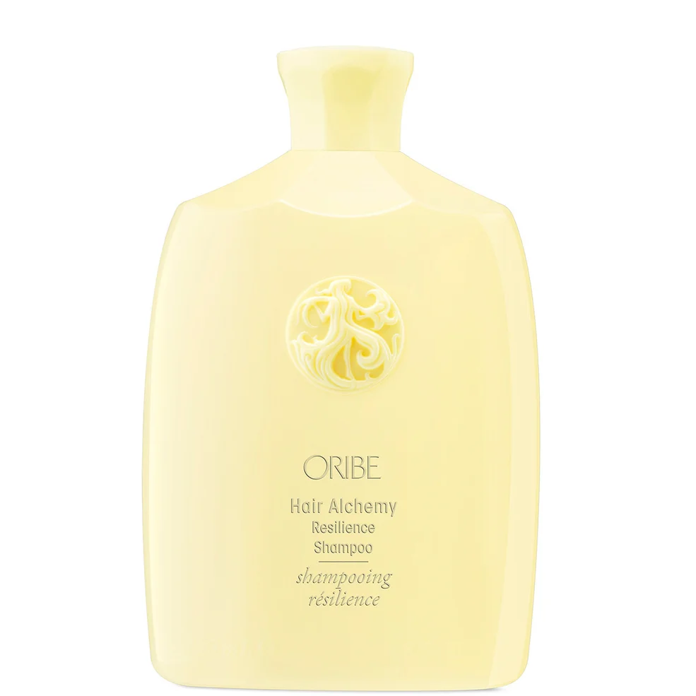 A pale yellow bottle of ORIBE Hair Alchemy Resilience Shampoo on a solid white background.