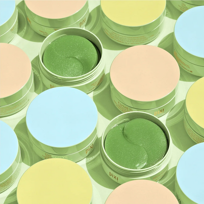 A top-down view of multiple round cosmetic jars arranged in a pattern. Two jars are open, showing a green eye mask product inside, while others have pastel peach, light blue, and pale yellow lids.