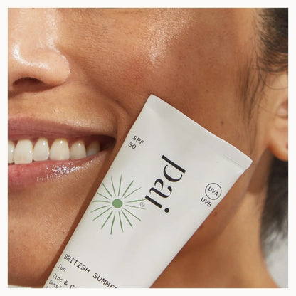 Close-up of a person applying PAI sunscreen to their face with a focus on the product.