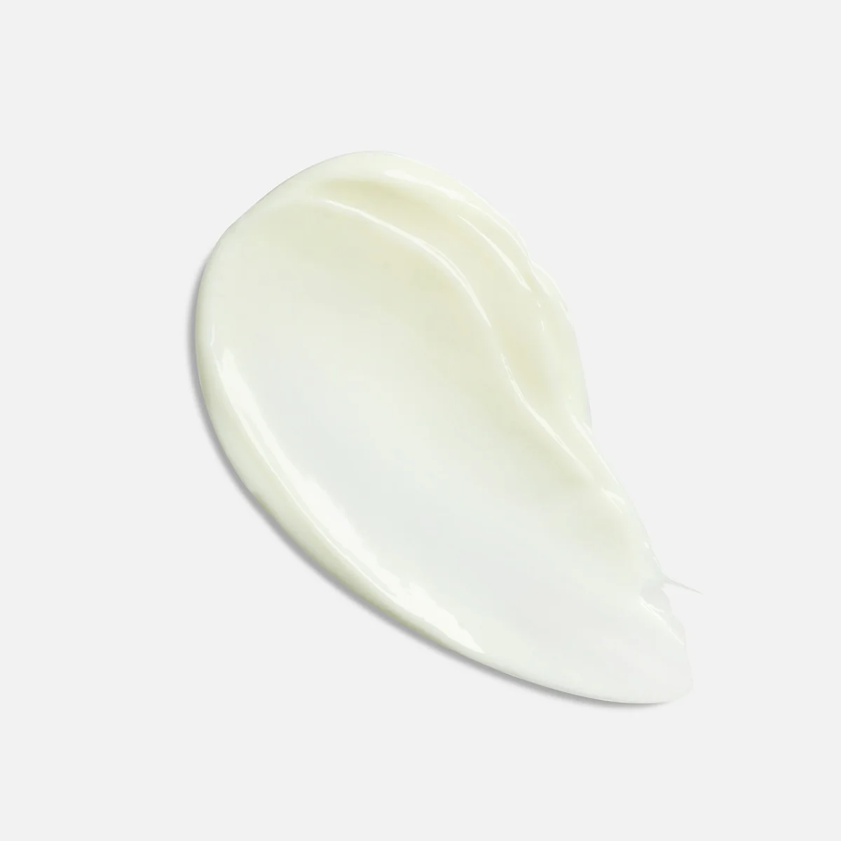 A smooth, creamy swatch of off-white lotion or cream with a glossy finish, presented on a clean, light gray background.