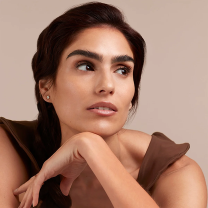 Woman with a neutral expression against a beige background