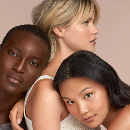 Three models posing closely together against a solid pale beige background, wearing matching light beige knit tops.
