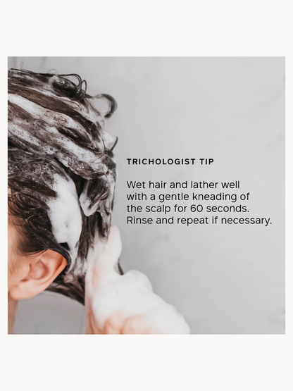 Person washing hair with a trichologist tip on a gray background