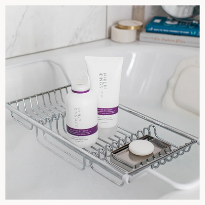 Bathroom shelf with skincare products on a white tiled wall