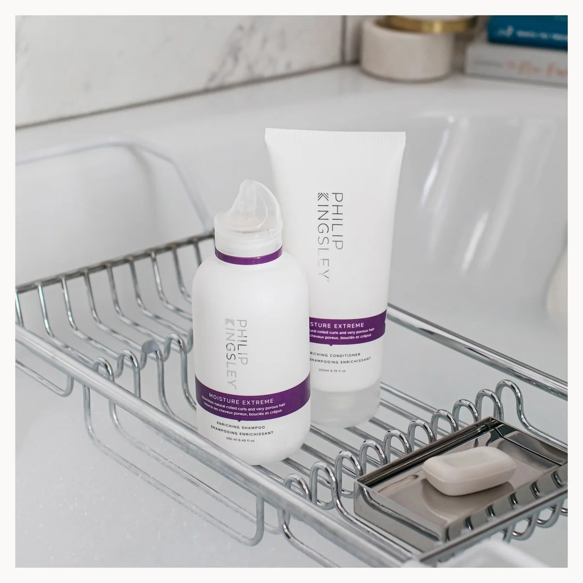 Philips Haircare hair extension care products, including a white bottle and tube with purple bands, displayed on a chrome wire bathroom sink caddy.
