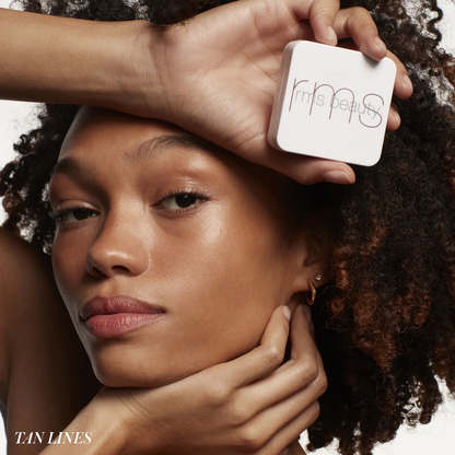 Person holding a RMS Beauty product with a neutral background