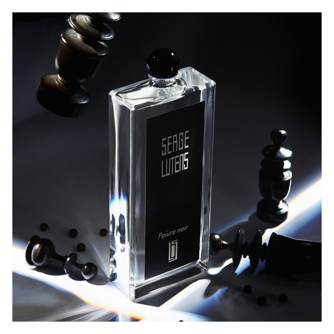 Serge Lutens perfume bottle with chess pieces on a dark background