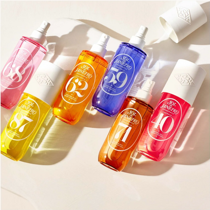 Five bottles of SK Innenseen sunscreen spray in different vibrant colors (pink, yellow, orange, blue, red) arranged diagonally on a light beige background with soft shadows.
