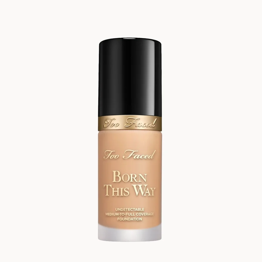 Too Faced Born This Way liquid foundation in a clear bottle showing the beige foundation shade, topped with a black cap and a gold band.