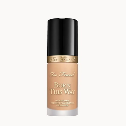 Too Faced Born This Way liquid foundation in a clear bottle showing the beige foundation shade, topped with a black cap and a gold band.