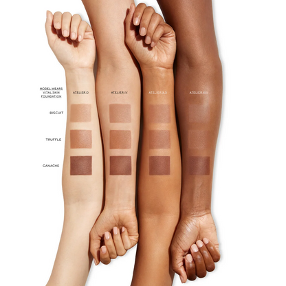 Four arms with swatches of foundation on a white background