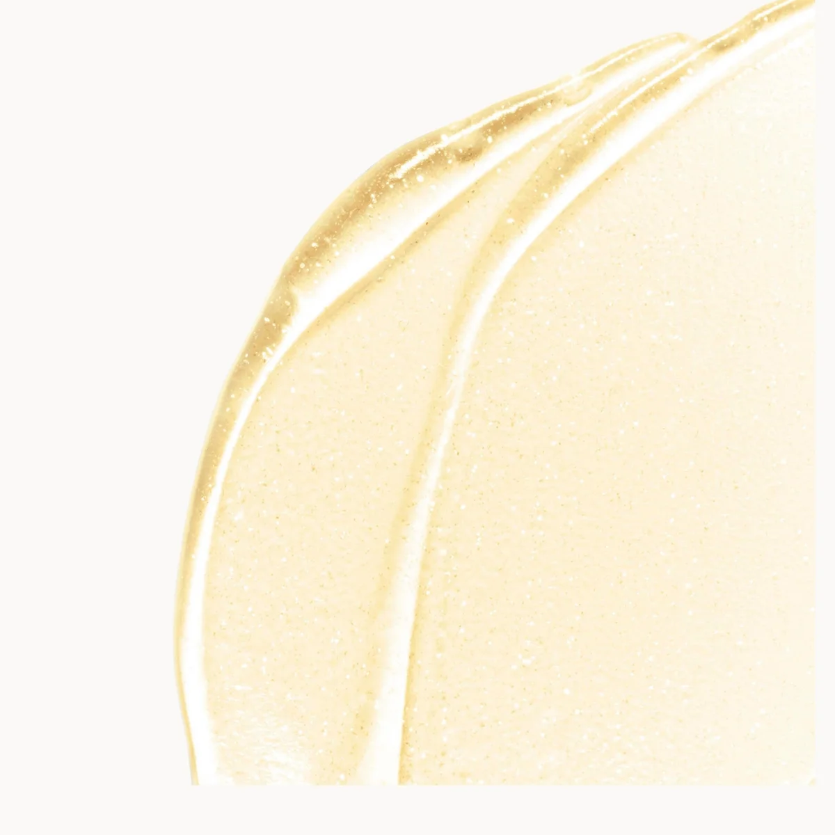 A close-up swatch of a pale, shimmering YSL Primer on a white background.