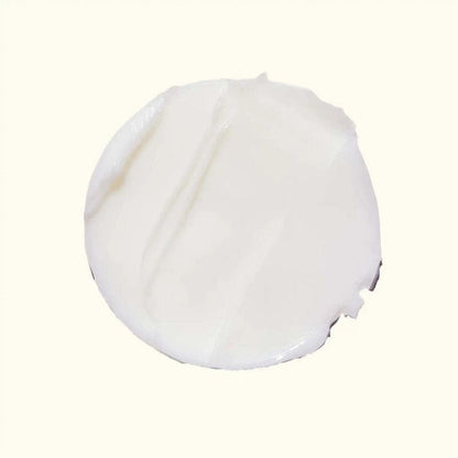 A dollop of thick, creamy white cosmetic cream or lotion on a solid off-white background.