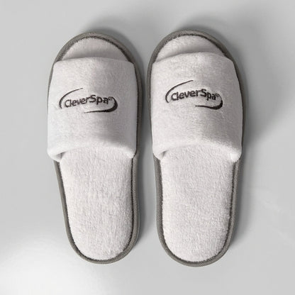 A pair of white terry cloth slide slippers with gray trim and the CleverPys brand logo printed on the straps, shown from a top-down view on a light gray background.
