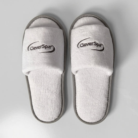 A pair of white terry cloth slide slippers with gray trim and the CleverPys brand logo printed on the straps, shown from a top-down view on a light gray background.