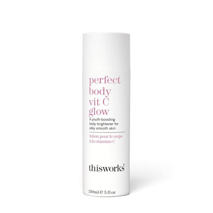 A white cylindrical bottle of thisworks Perfect Body Vit C Glow body brightener, featuring pink and black text on a clean white background.